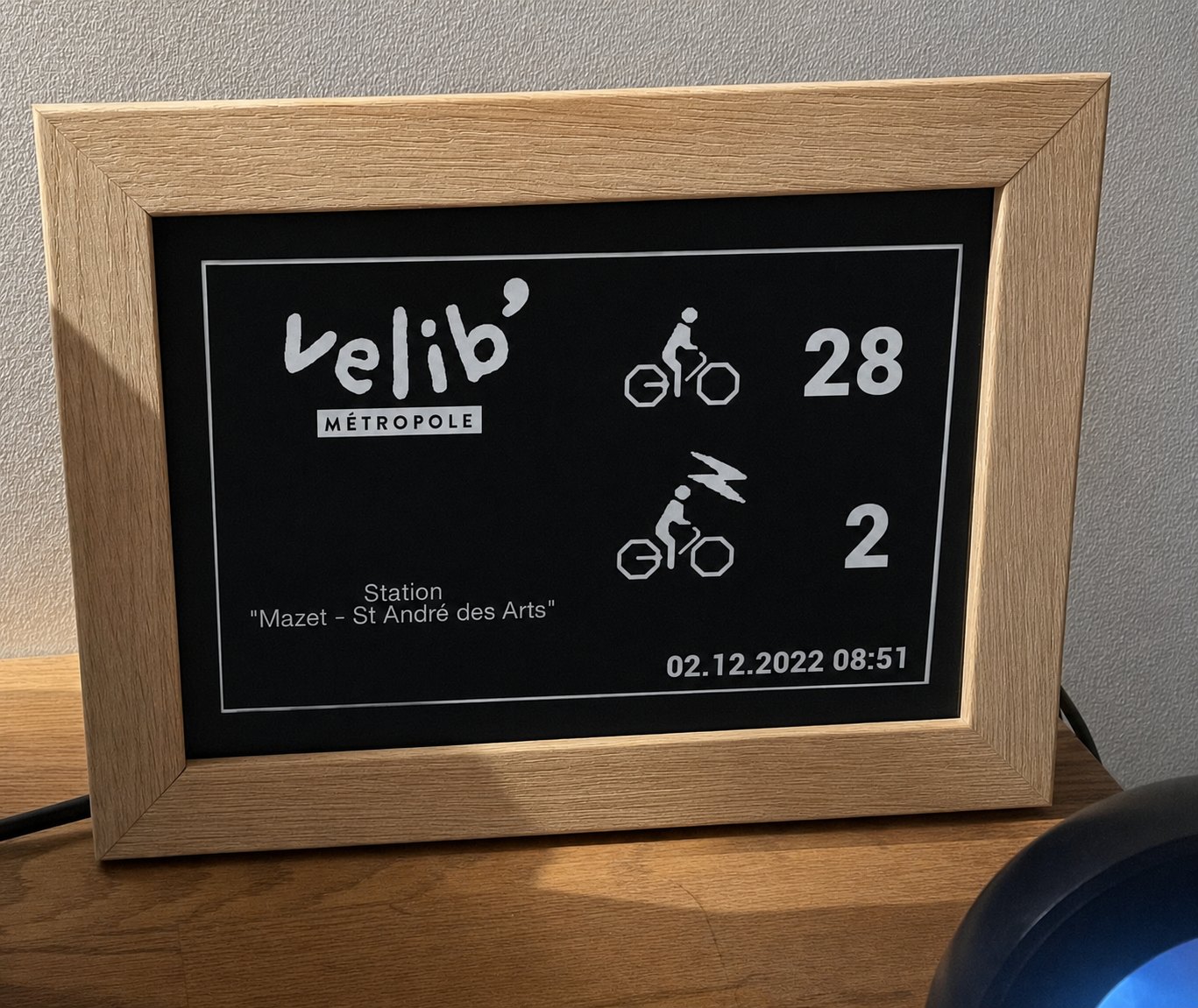 Cadre de chêne clair affichant les vélos disponibles à la station Mazet.
